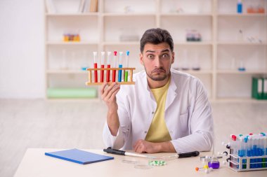 Young chemist sitting at the lab