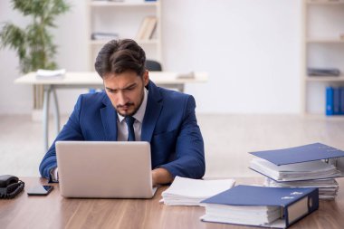 Genç işadamı ve ofiste çok fazla iş var.