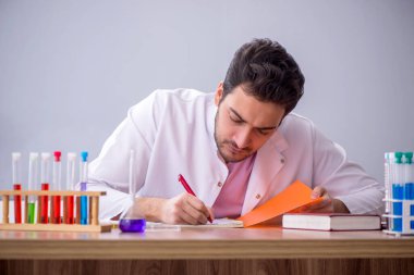 Young chemistry teacher sitting in the classroom