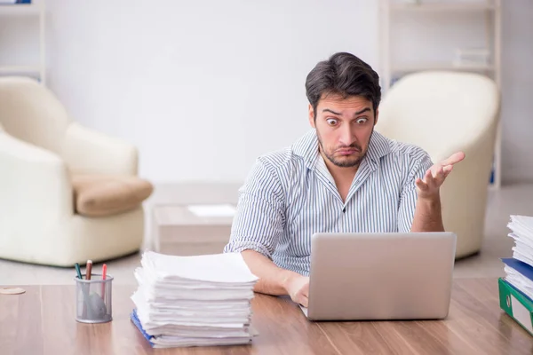 stock image Young employee and too much work at workplace