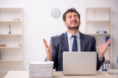 Genç bir çalışan ve ofiste çok fazla iş var.