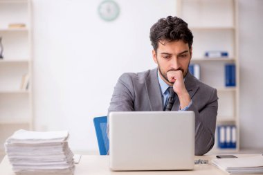 Genç bir çalışan ve ofiste çok fazla iş var.