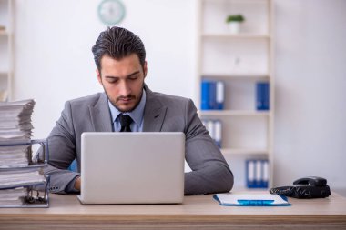 Genç bir çalışan ve ofiste çok fazla iş var.