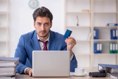 Kredi kartı tutan genç bir çalışan.