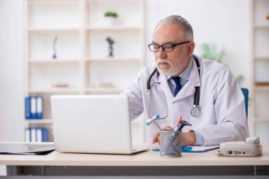 Teletıp konseptinde yaşlı bir doktor.