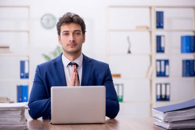 Young employee and too much work at workplace