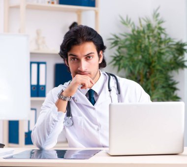 Klinikte çalışan yakışıklı genç doktor.