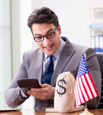 Ofisinde Amerikan bayrağı olan iş adamı.