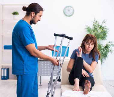 Doktor travmatoloğu ziyaret eden yaralı bir kadın.