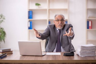 Ofiste çalışan eski bir işadamı.