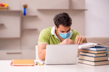 Genç öğrenci salgın sırasında evde sınavlara hazırlanıyor.