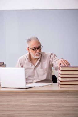 Old teacher sitting in the classroom