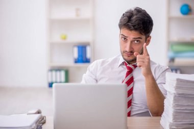 Ofisteki aşırı işten memnun olmayan genç bir çalışan.