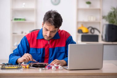 Laboratuvarda bilgisayar tamir eden genç bir tamirci.