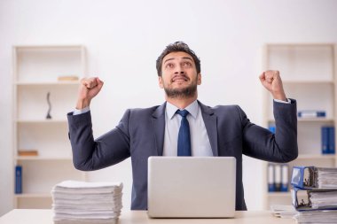 Genç bir çalışan ve ofiste çok fazla iş var.