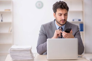 Genç bir çalışan ve ofiste çok fazla iş var.