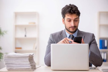 Genç bir çalışan ve ofiste çok fazla iş var.