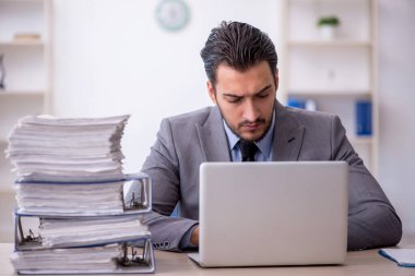 Genç bir çalışan ve ofiste çok fazla iş var.