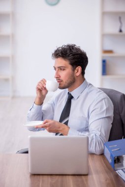 Molada kahve içen genç bir çalışan.
