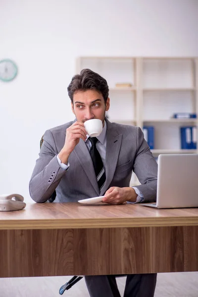 休憩中に若い従業員がコーヒーを飲む — ストック写真