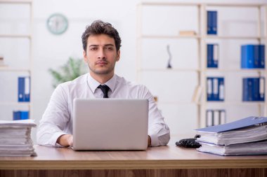 Young employee and too much work at workplace