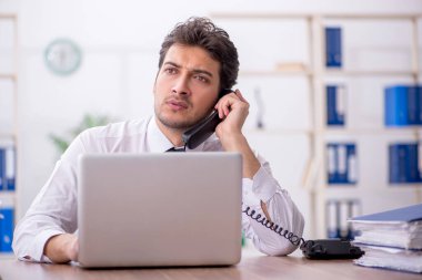 Young employee and too much work at workplace