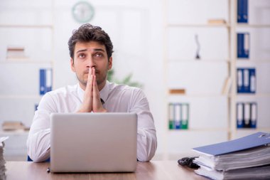 Young employee and too much work at workplace