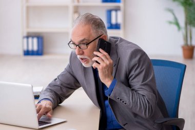 Ofiste telefonla konuşan eski bir çalışan.