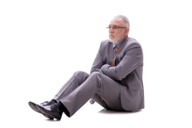 Yaşlı işadamı, beyaz zeminde tek başına oturuyor.