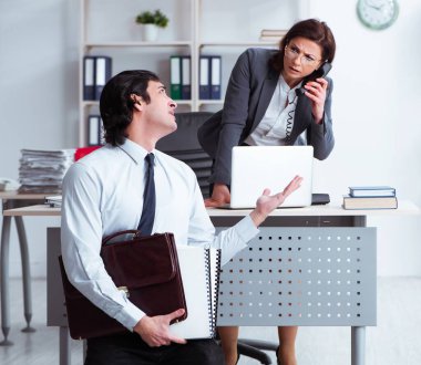 Yaşlı kadın patron ve genç erkek çalışan ofiste.