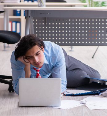 Genç erkek çalışan aşırı işten memnun değil.