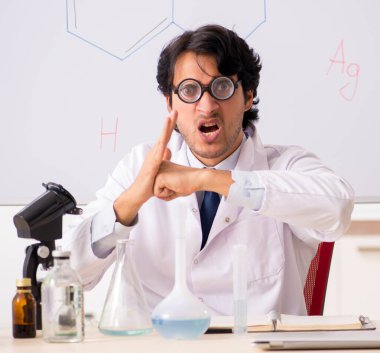 Beyaz panonun önündeki komik genç kimyager.