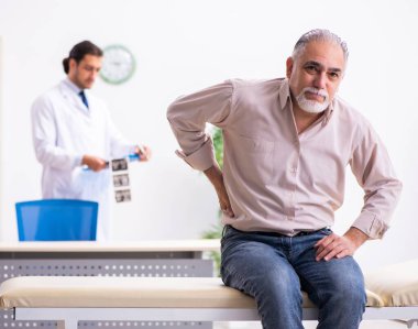 Yaşlı hasta genç doktoru ziyaret ediyor.