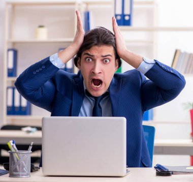 Genç erkek çalışan aşırı işten memnun değil.