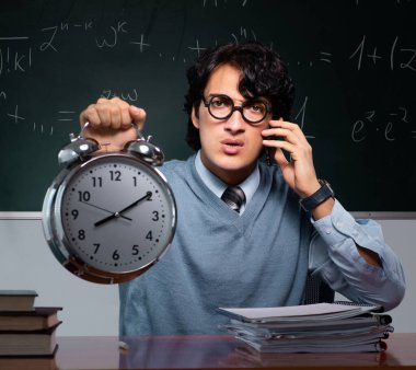 Tahtanın önündeki genç matematik öğretmeni.