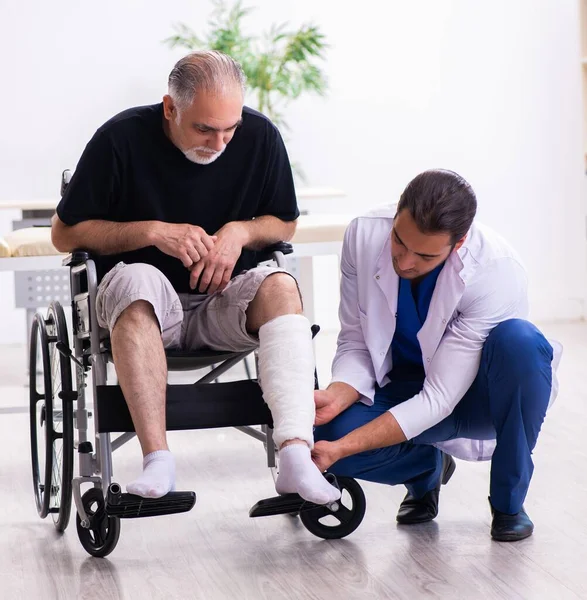 Old Injured Man Visiting Young Doctor Traumatologist — Stock Photo, Image