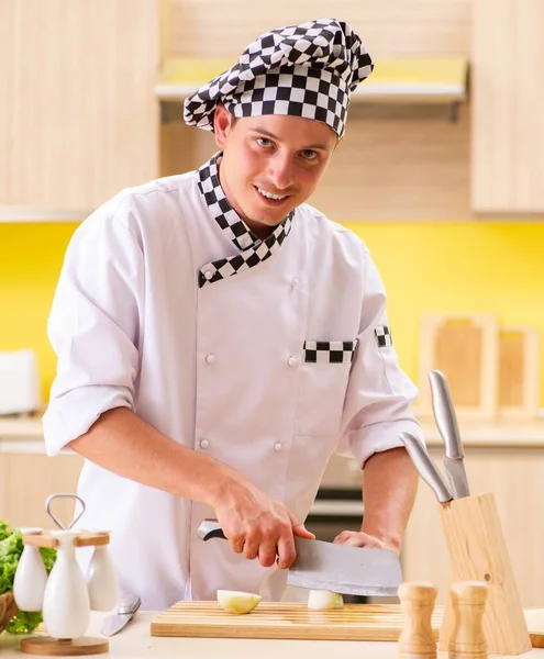 若いプロの料理人がキッチンでサラダを作る — ストック写真