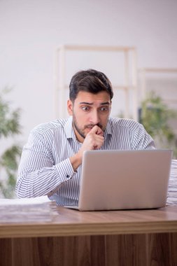 Genç işadamı ve işyerinde çok fazla iş var.