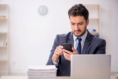 Genç bir çalışan ve ofiste çok fazla iş var.