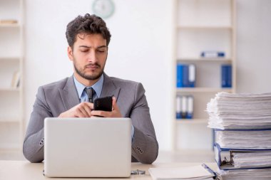 Genç bir çalışan ve ofiste çok fazla iş var.