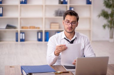 Genç işadamı işyerinde oturuyor.