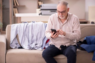 Aged man preparing for trip at home