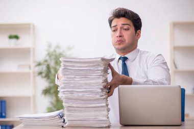 Genç işadamı ve işyerinde çok fazla iş var.