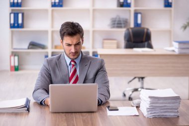 Genç işadamı işyerinde oturuyor.