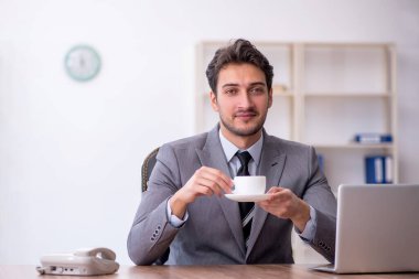 Molada kahve içen genç bir çalışan.