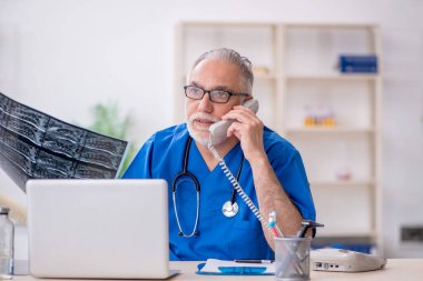 Klinikte çalışan yaşlı bir radyolog.