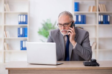 Eski bir çalışan iş yerinde telefonla konuşuyor.