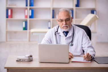 Teletıp konseptinde yaşlı bir doktor.