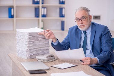 Eski bir işadamı ve işyerinde çok fazla iş var.