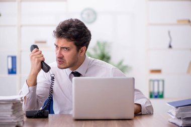 Young employee and too much work at workplace